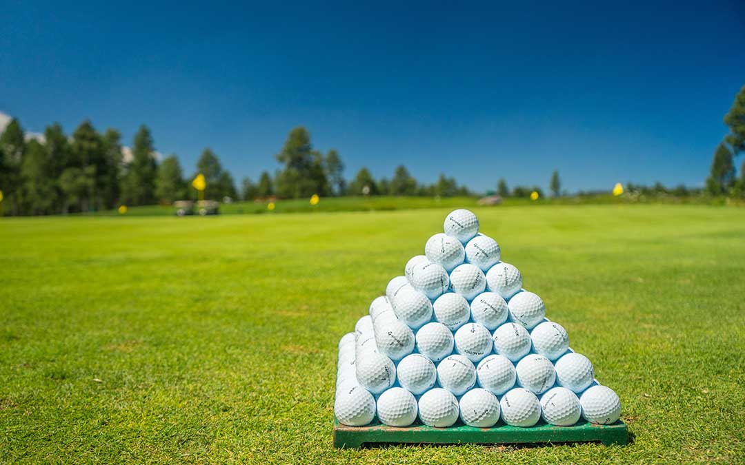 Close-up of two golf balls on the green after chip shots showing different spin rates