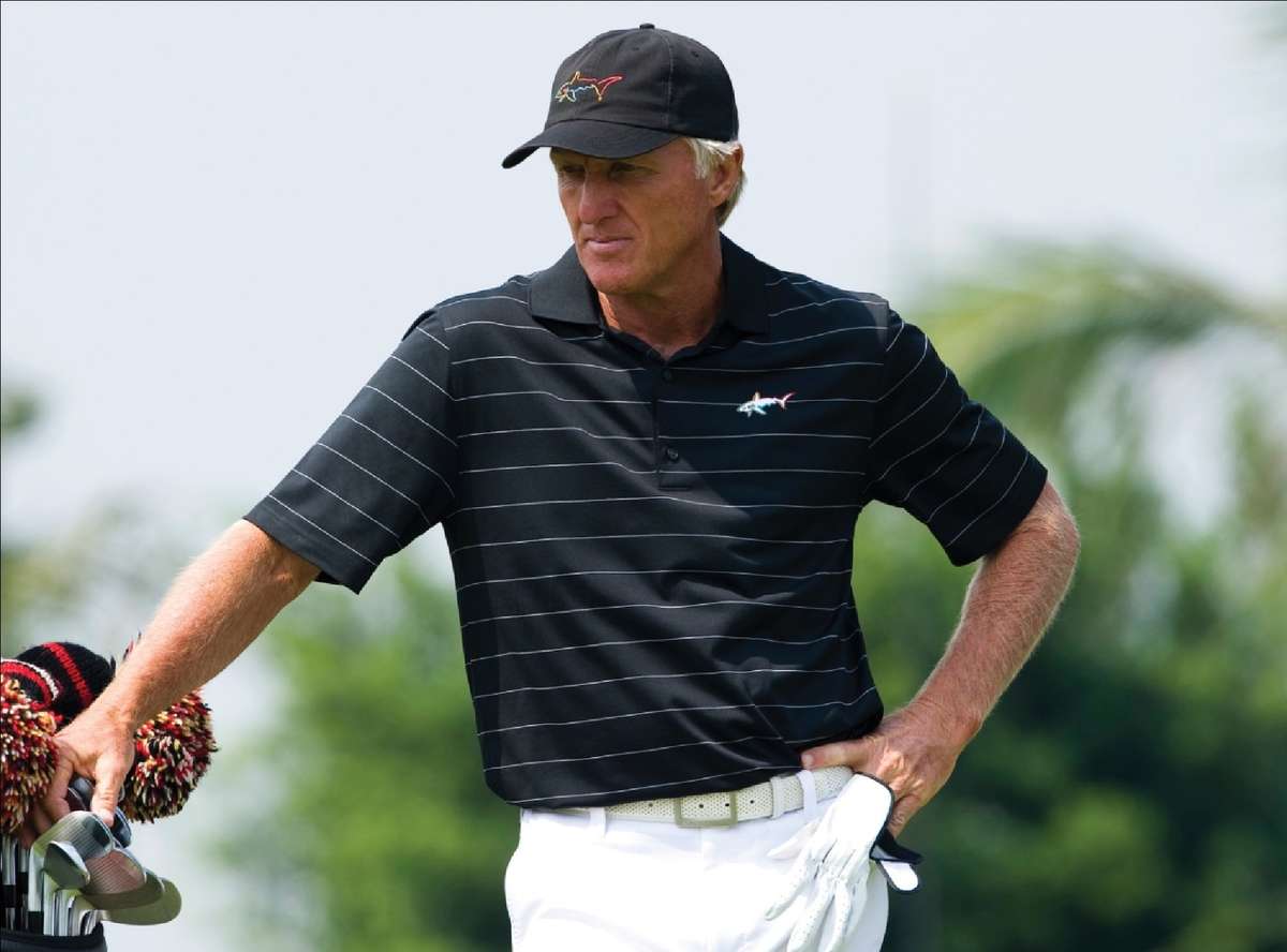 Greg Norman celebrating after winning The Open Championship, raising his arms on the 18th green