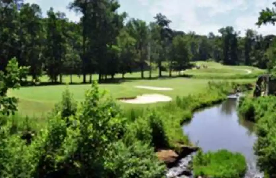 Wide view of Hard Labor Creek with open horizon, low fescue grasses and a wind-swept fairway stretching toward the sea
