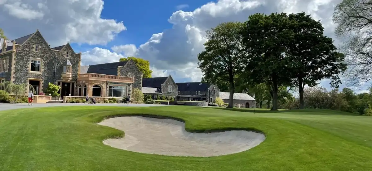 Historic Prestwick clubhouse exterior with weathered stone and soft evening light evoking calm heritage