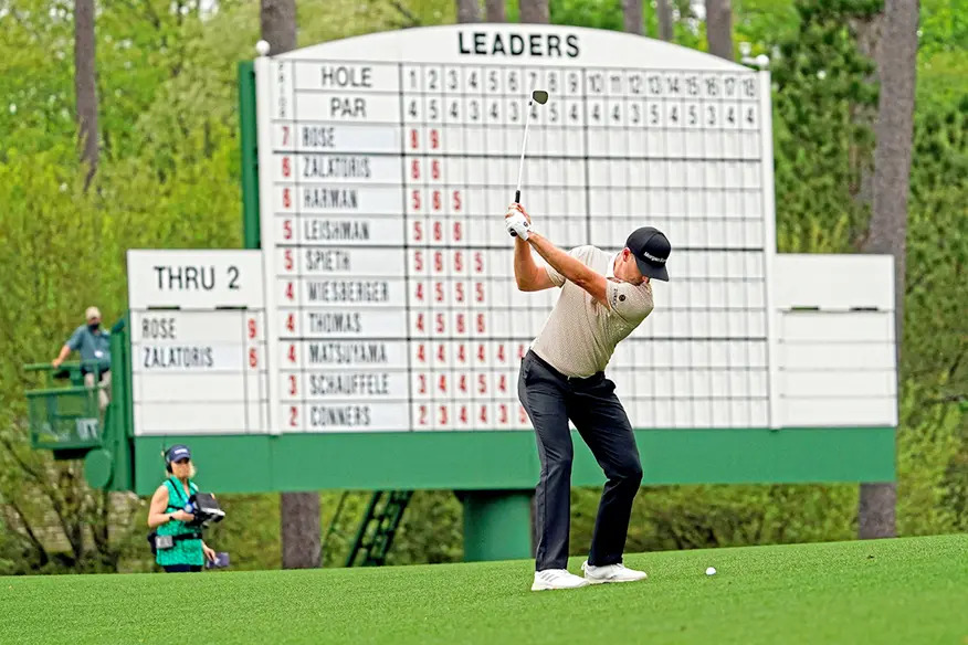 Rory McIlroy holding the green jacket on the 18th green after winning the 2026 Masters