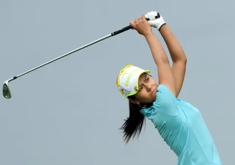 Close-up of a golfer’s putting stance showing distinctive grip and posture on a green